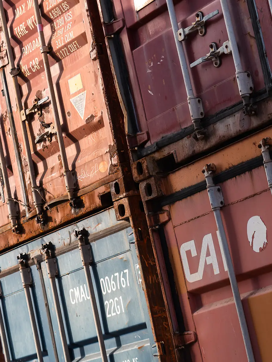 Containers maritimes d’occasion empilés présentant des traces d’usure liées au transport