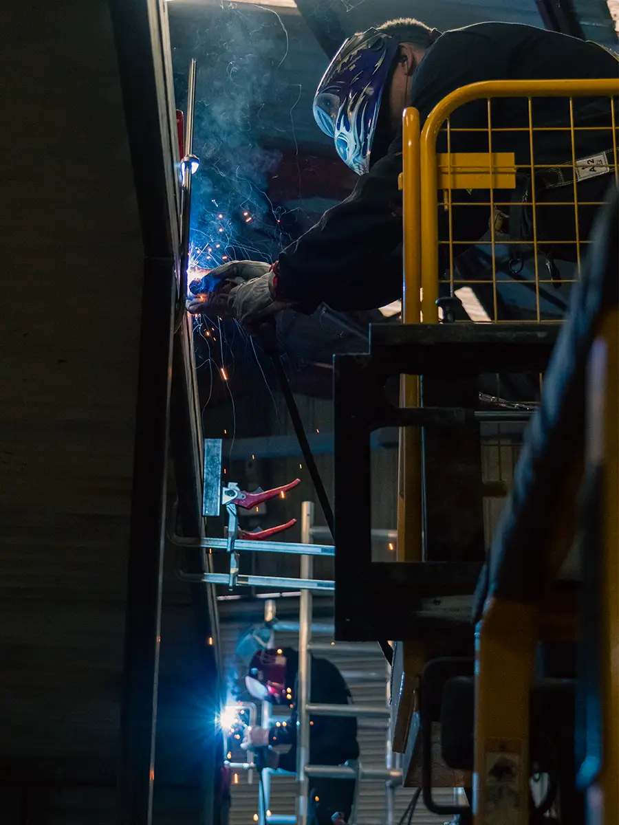 Technicien Bluetainer réalisant une opération de soudure sur un container maritime en cours d’aménagement