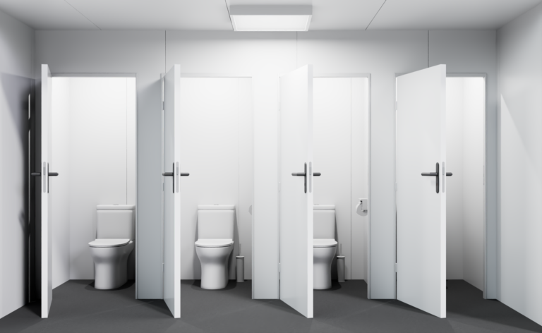 Intérieur d'un bloc sanitaire conteneur avec trois cabines WC équipées.